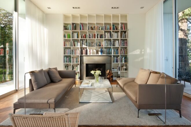 a large living space with two sofas and built-in book shelves