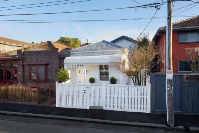 white cottage house with white picket fence