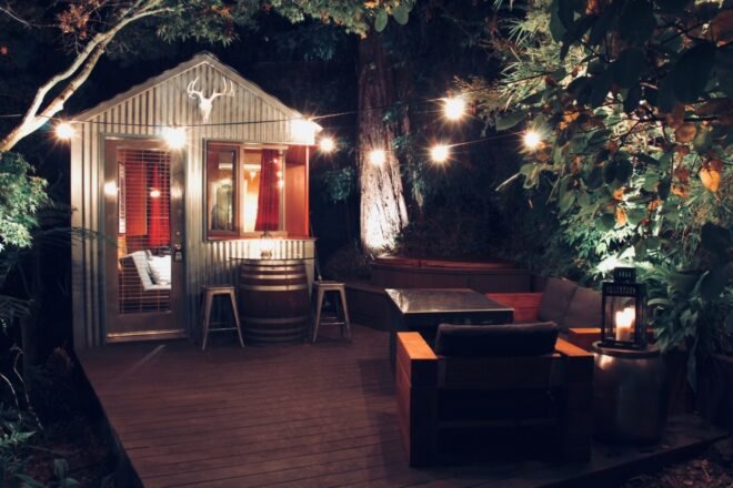 a tiny shed with pitched roof surrounded by a wooden deck