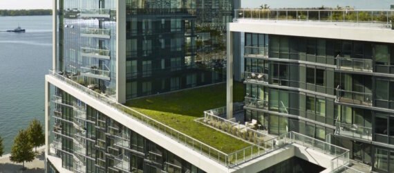 condo building with glass walls and a green roof