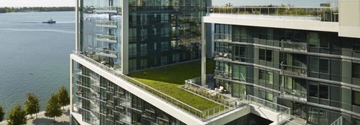 condo building with glass walls and a green roof