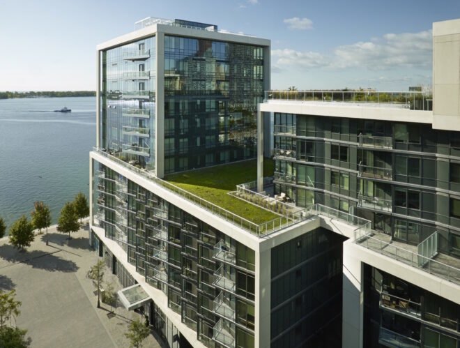 condo building with glass walls and a green roof