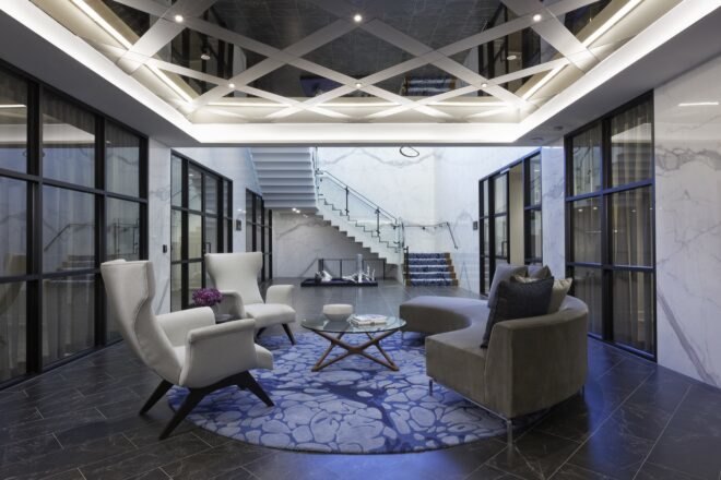 white chairs and gray sofa under a patterned ceiling