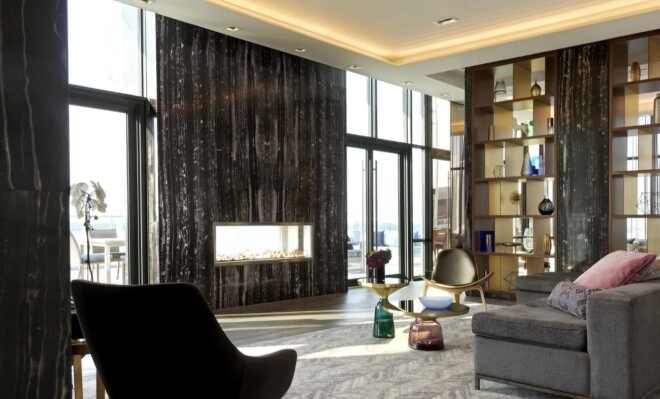 gray sofa and black chair facing a wall of glass