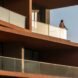 man standing out on balcony with glass balustrades