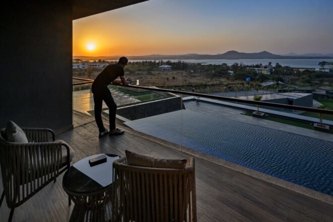 man looking out onto swimming pool