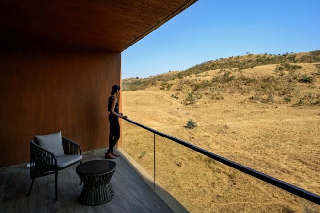 man looking out over covered balcony