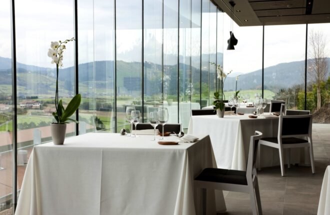 cloth-covered tables beside walls of glass