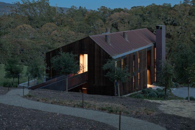 evening shot of large wood home with pitched roof