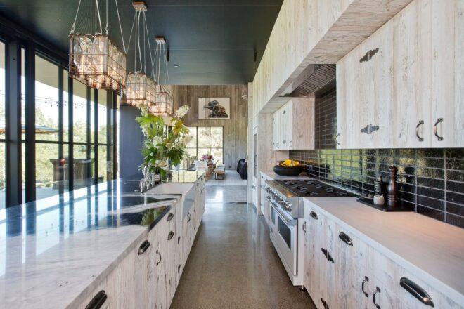 large kitchen with pendant lights and white cabinets and island