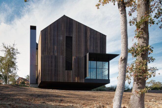 barn-shaped home with modern glass patio