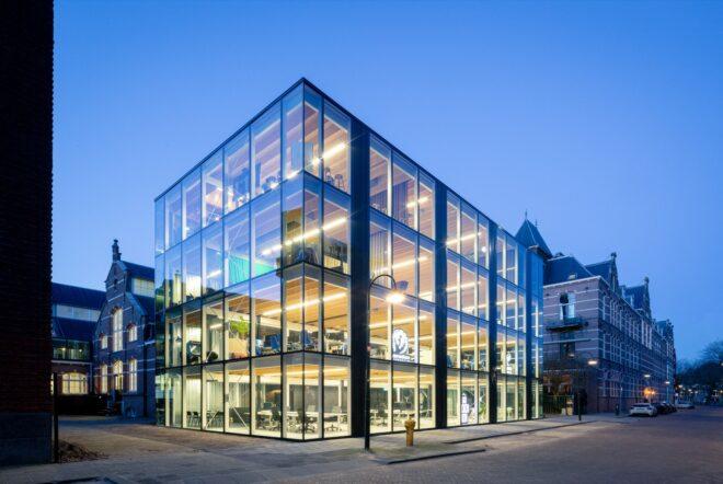 glass office building lit from within at dusk