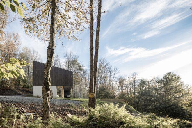 an daytime shot of an angular building surrounded by trees