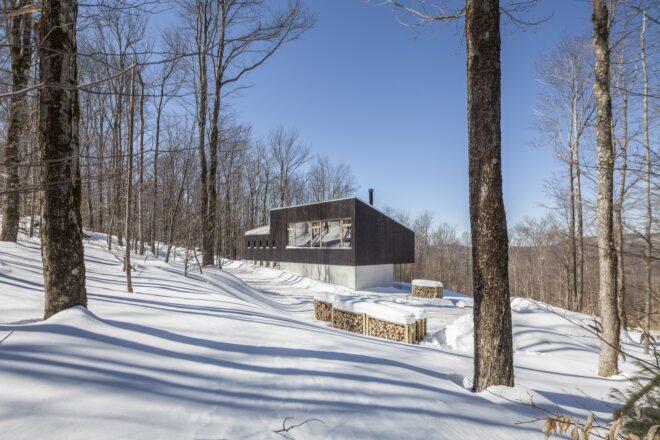 exterior of the home from afar, with a landscape covered in snow