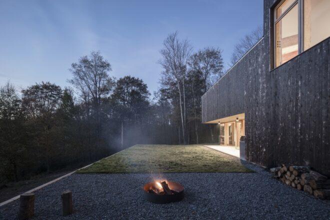 closeup of the homes backyard, with a lit firepit