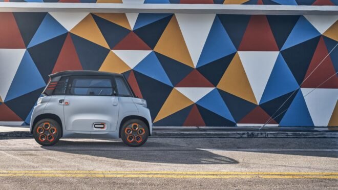 gray electric car next to a colorful patterned wall mural
