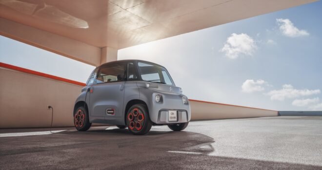 tiny gray electric car in a parking garage
