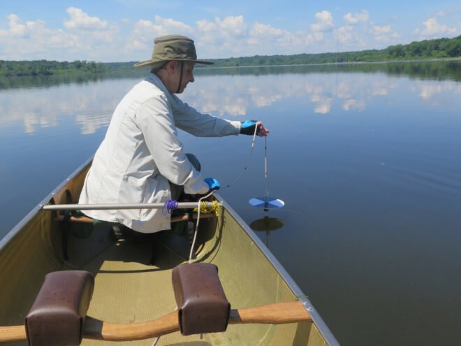 person in boat monitoring lake pollution