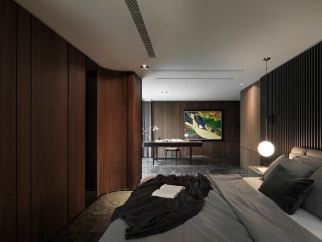 gray bed in a room with wood paneling