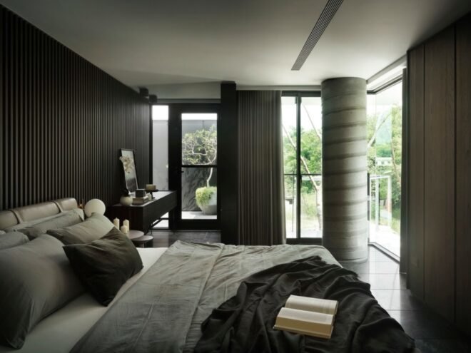 gray bed facing wood paneled wall
