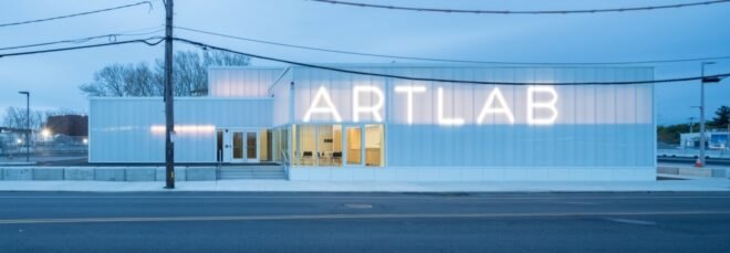 a close-up, nighttime, street-view of a short, rectangular white building with "ARTLAB" written on the outside