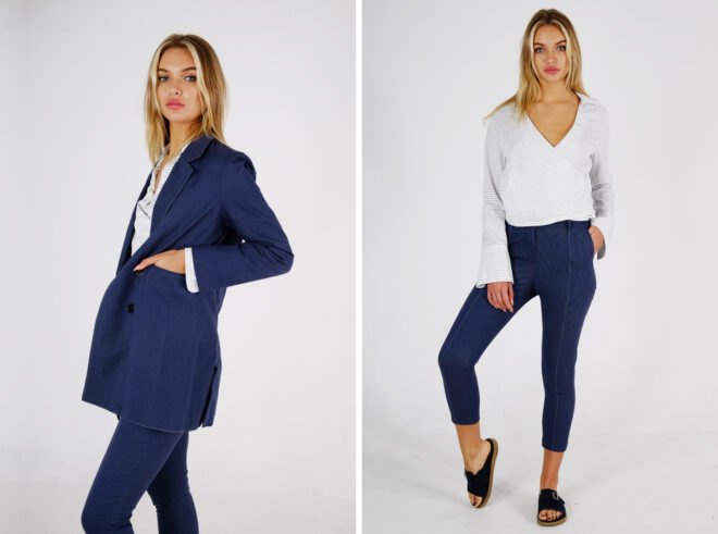 person wearing tailored navy jacket and pants with a white and gray striped blouse