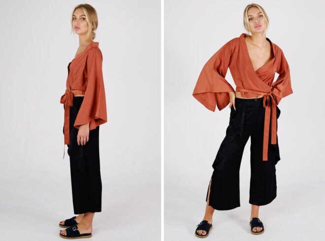 person wearing orange blouse with flowing sleeves and wide-leg black pants