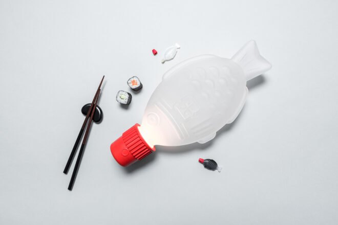 white and red fish-shaped lamp near fish-shaped soy sauce packet and sushi