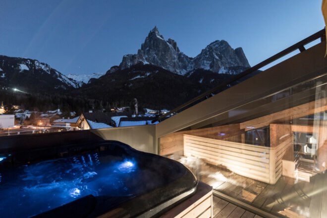 hot tub on a wood balcony with mountains in the distance