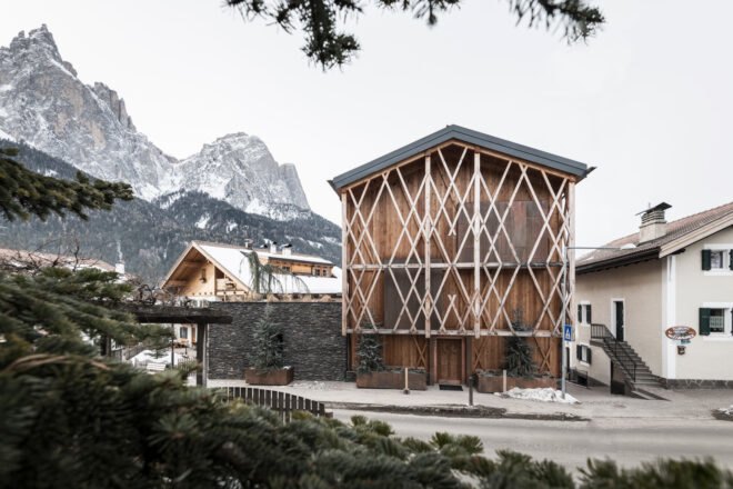 artistic wood trellis over a wooden gabled home