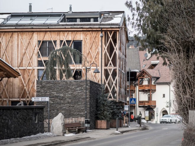 wooden gabled home surrounded by other gabled homes and business buildings
