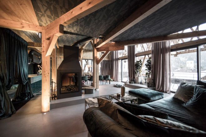 velvet sofa facing a wood-burning fireplace