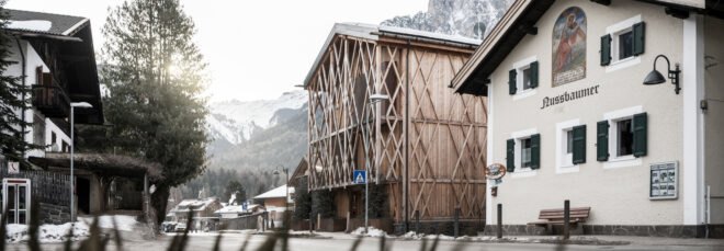 gabled wood home with patterned trellis covering the house