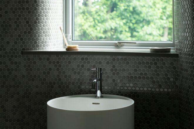 bathroom sink in front of large square window