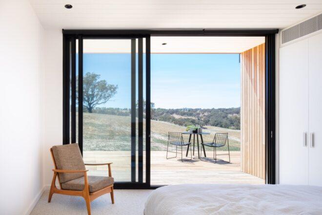 white room with tan chair near a sliding glass door