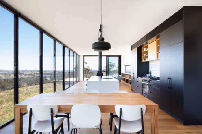 wood table near a black and white kitchen
