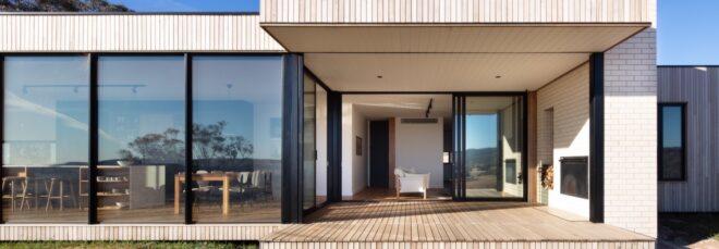 light wood home with several windows and a large front porch