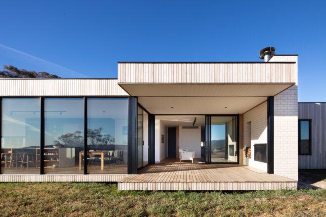 light wood home with several windows and a large front porch