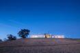 long prefab home on a hill at dusk