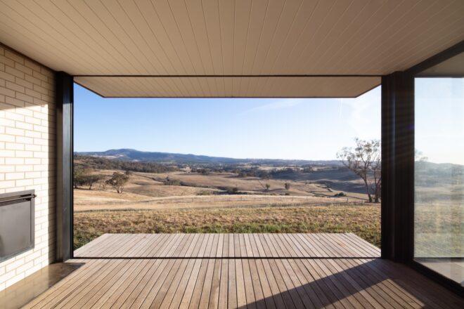 covered wood porch facing hilly farmland