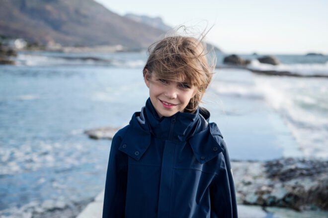 child in blue jacket smiling
