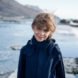 child in blue jacket smiling