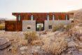 two-story home surrounded by dry desert landscape