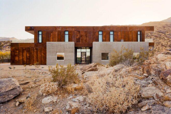 two-story home surrounded by dry desert landscape