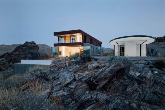 two-story home illuminated from within at dusk