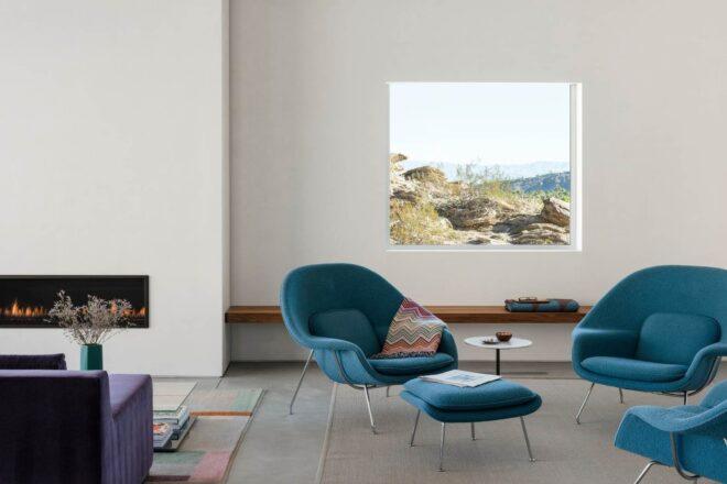 small seating area with two blue chairs and a footrest