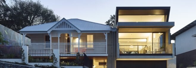 black modern cube home next to white gabled cottage