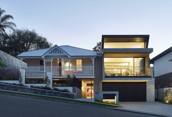 black modern cube home next to white gabled cottage
