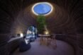 people hanging out in round room with skylight
