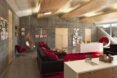 the interior of a room with red furniture accents and a hanging chair